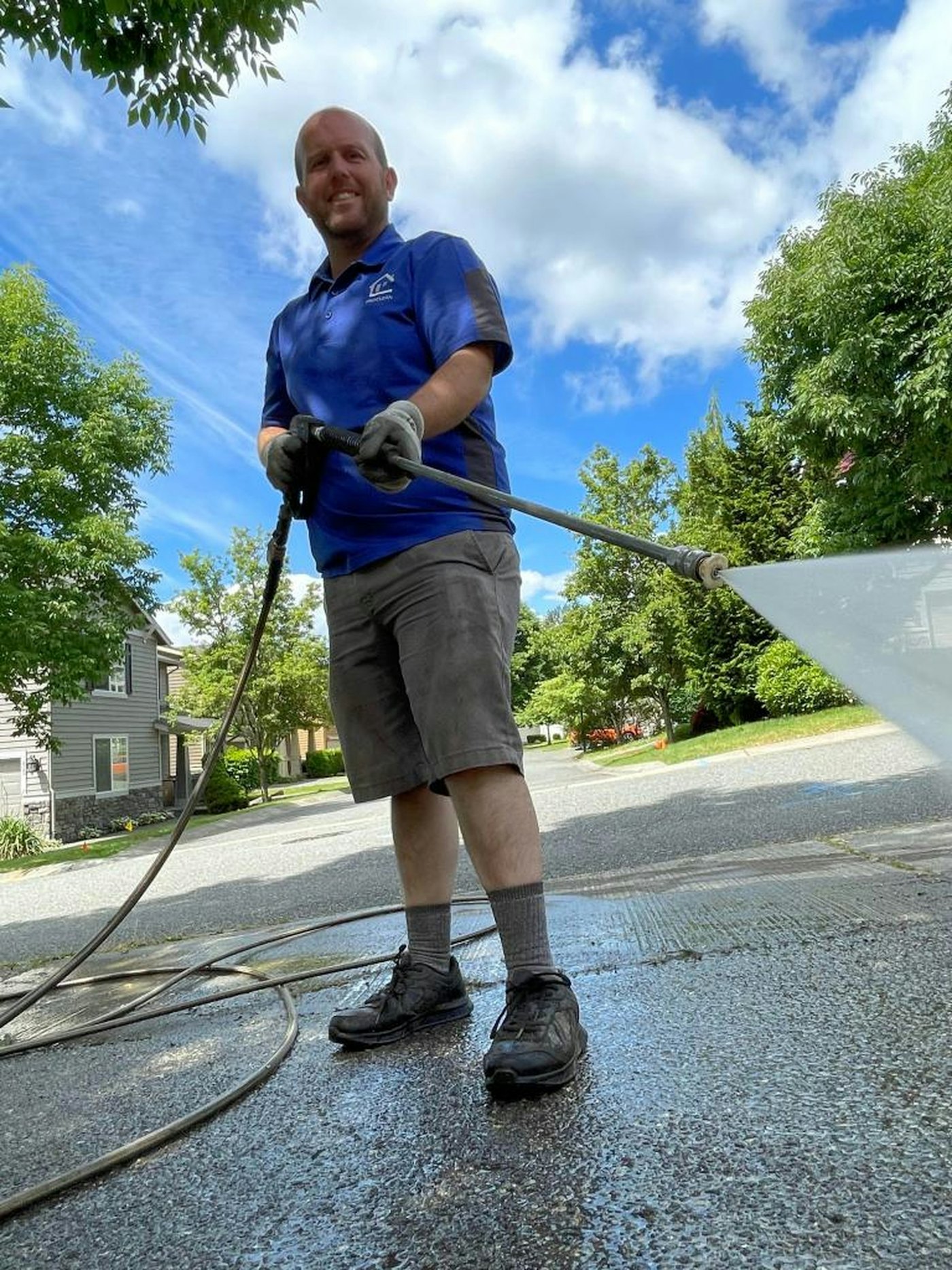 Technician pressure washing a residential driveway